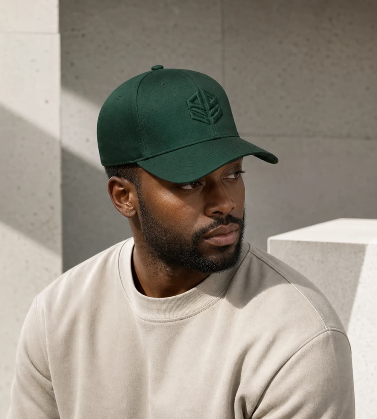 Representative styling concept of a model wearing a forest-green six-panel cap with tonal geometric embroidery